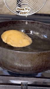 Poori puffing in hot oil while frying