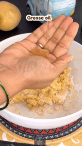 Hands kneading soft poori dough with oil