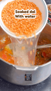 Adding soaked masoor dal and water to cooker