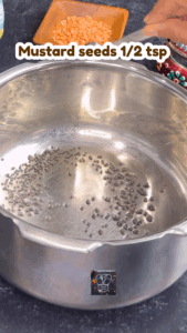 Mustard and cumin seeds spluttering in hot ghee