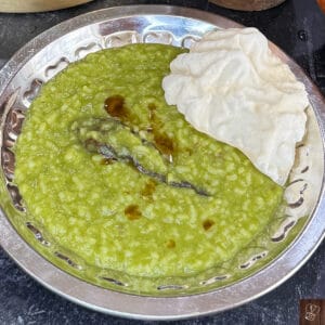 Healthy spinach and lentil khichdi served with crispy papad. Perfect traditional South Indian comfor.
